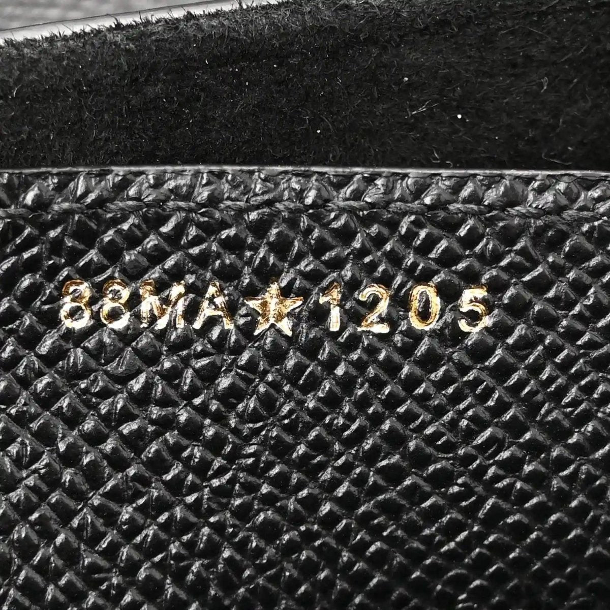 Gold stamped numbers on black grained leather interior lining