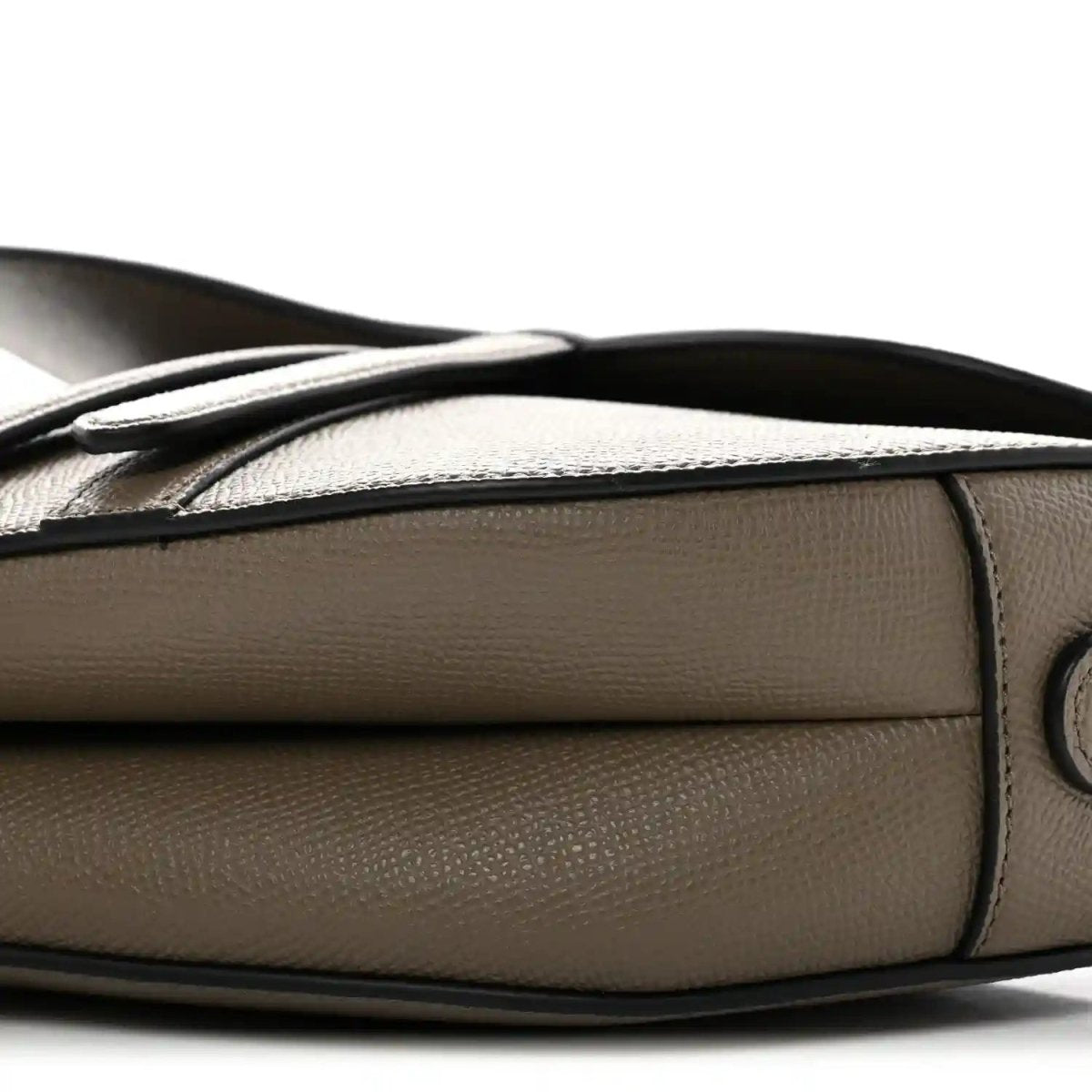 Close-up of dark green grained leather side with strap attachment and stitching