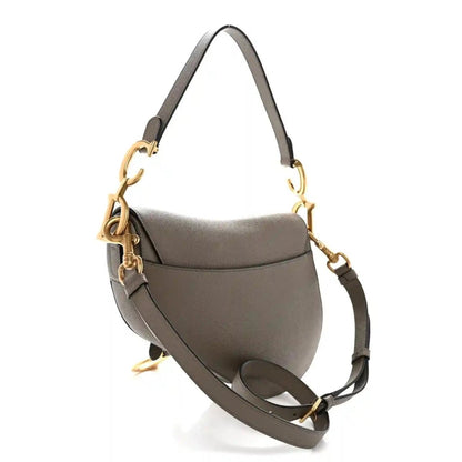 Grained calfskin saddle bag in dark green with flap, adjustable strap, and gold-tone clasp