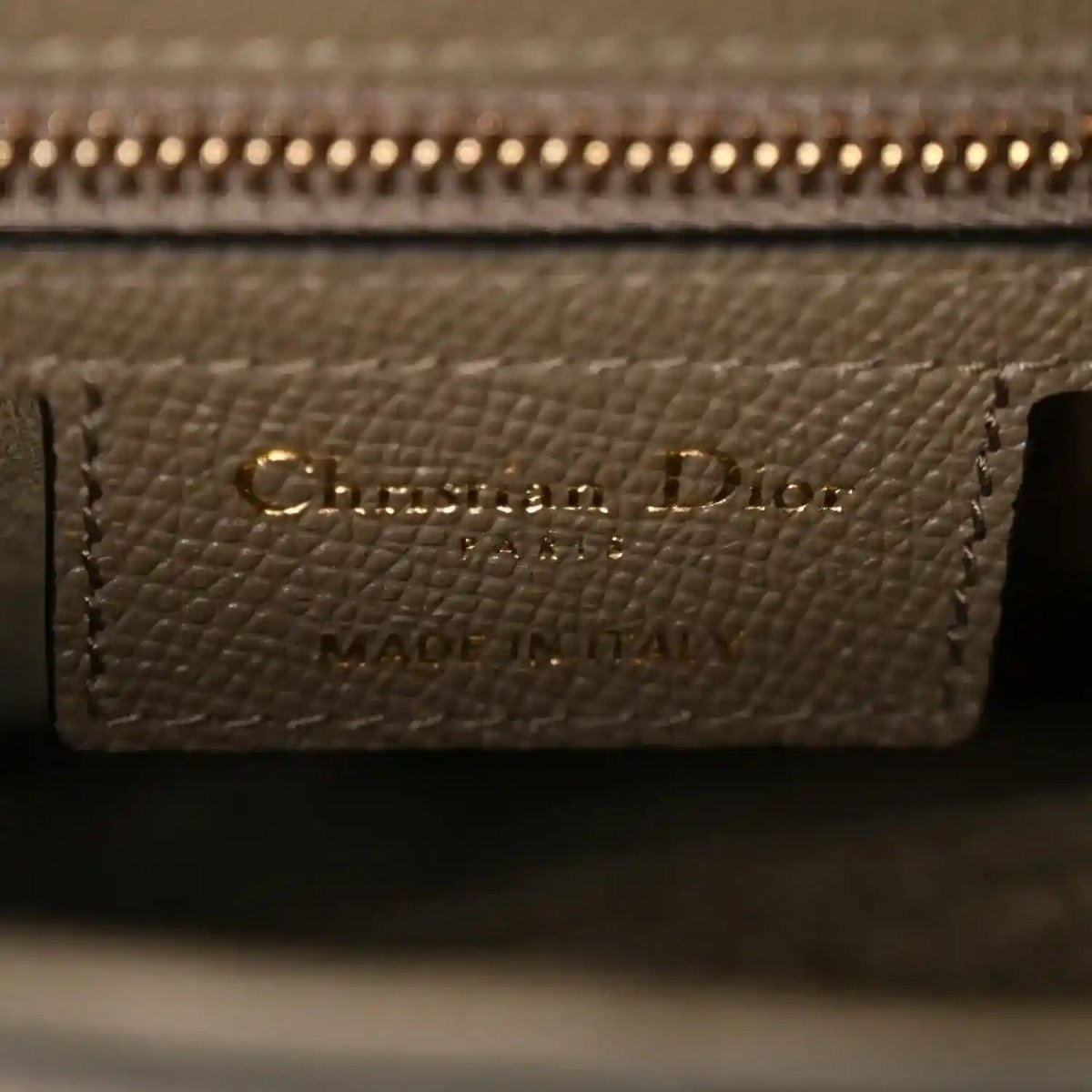 Close-up of Christian Dior label on grained dark green leather interior pocket