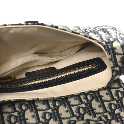 Saddle shoulder bag interior with beige lining and black zip pocket and gold zipper