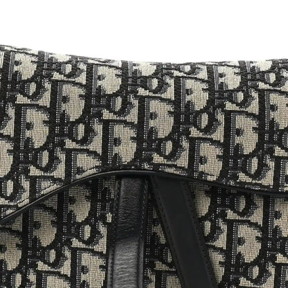 Dior Oblique monogram canvas saddle bag front with black leather center panel