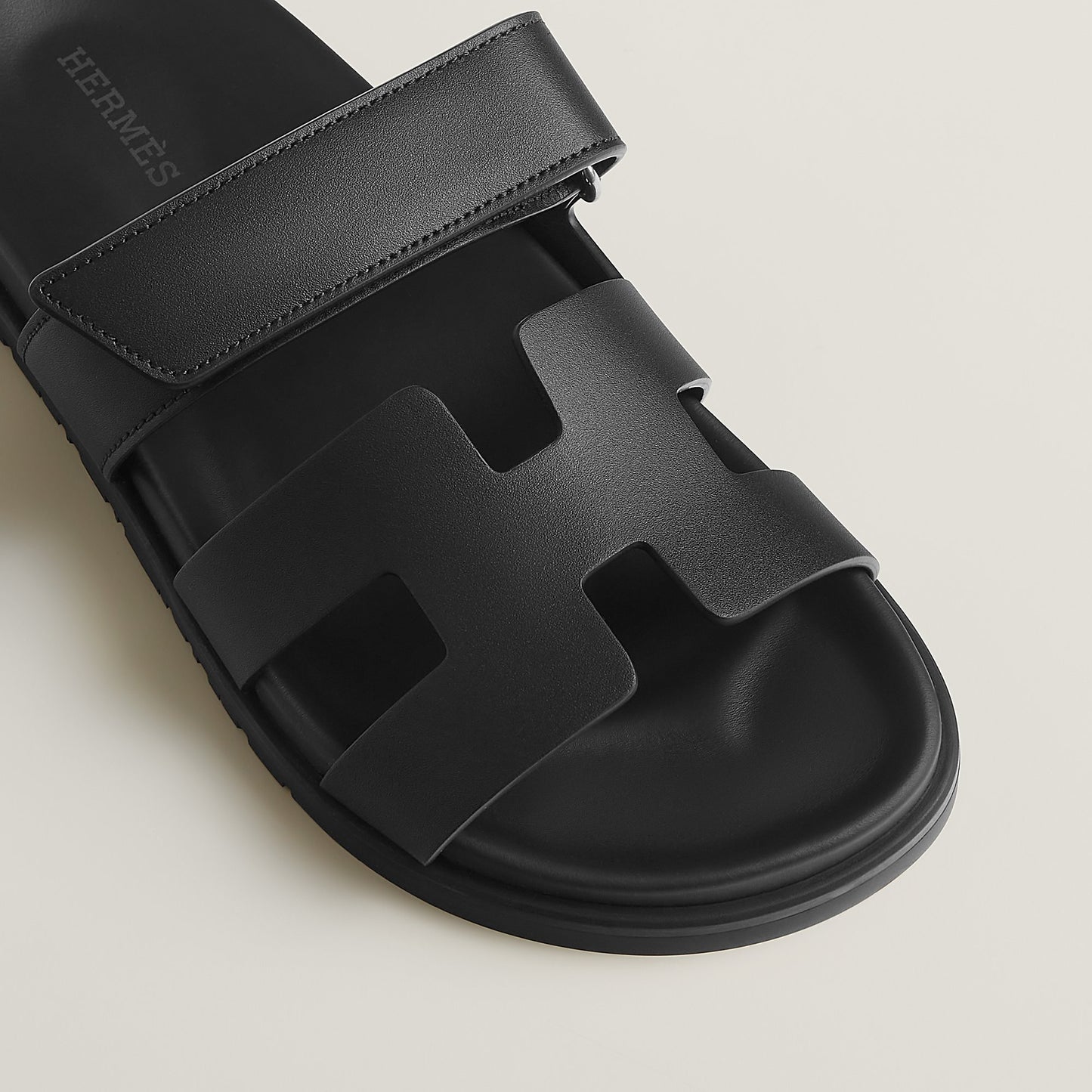 Black suede slide sandals close-up of wide strap and molded footbed