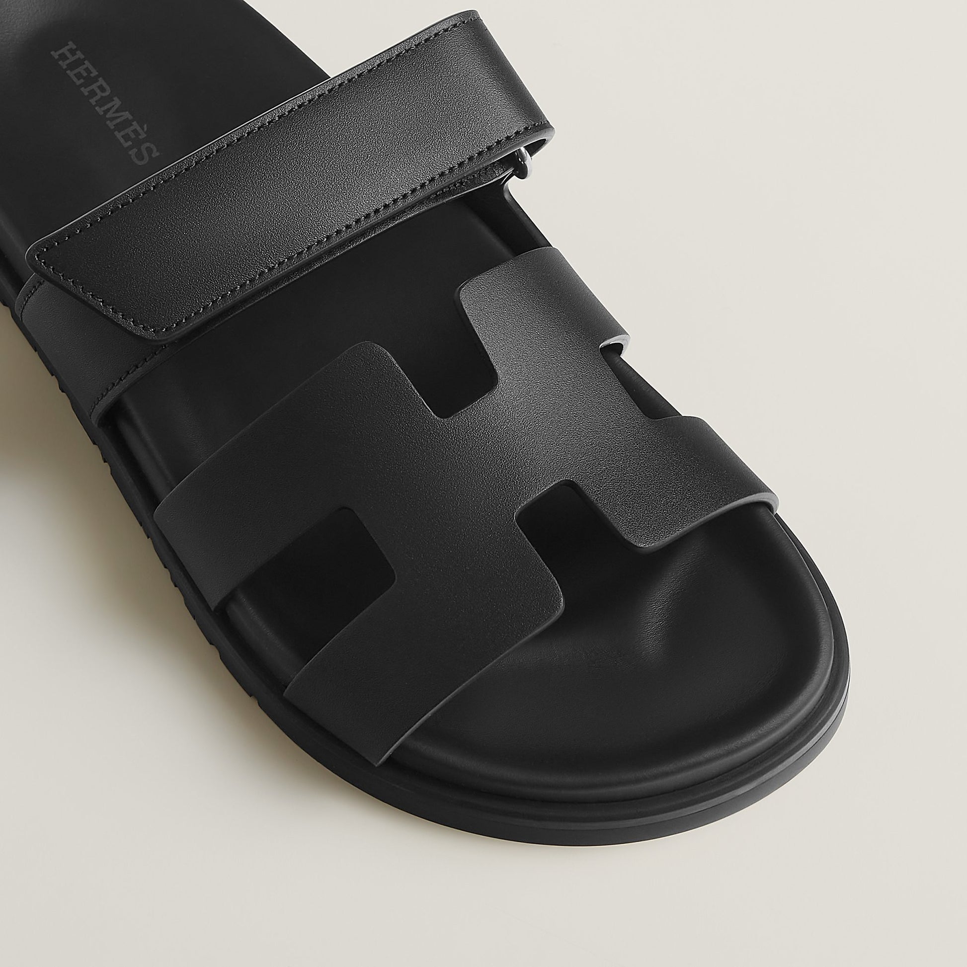 Black suede slide sandals close-up of wide strap and molded footbed
