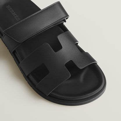 Black suede slide sandals close-up of wide strap and molded footbed