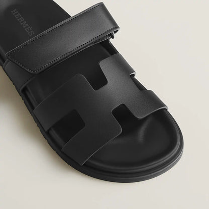 Black suede slide sandals close-up of wide strap and molded footbed