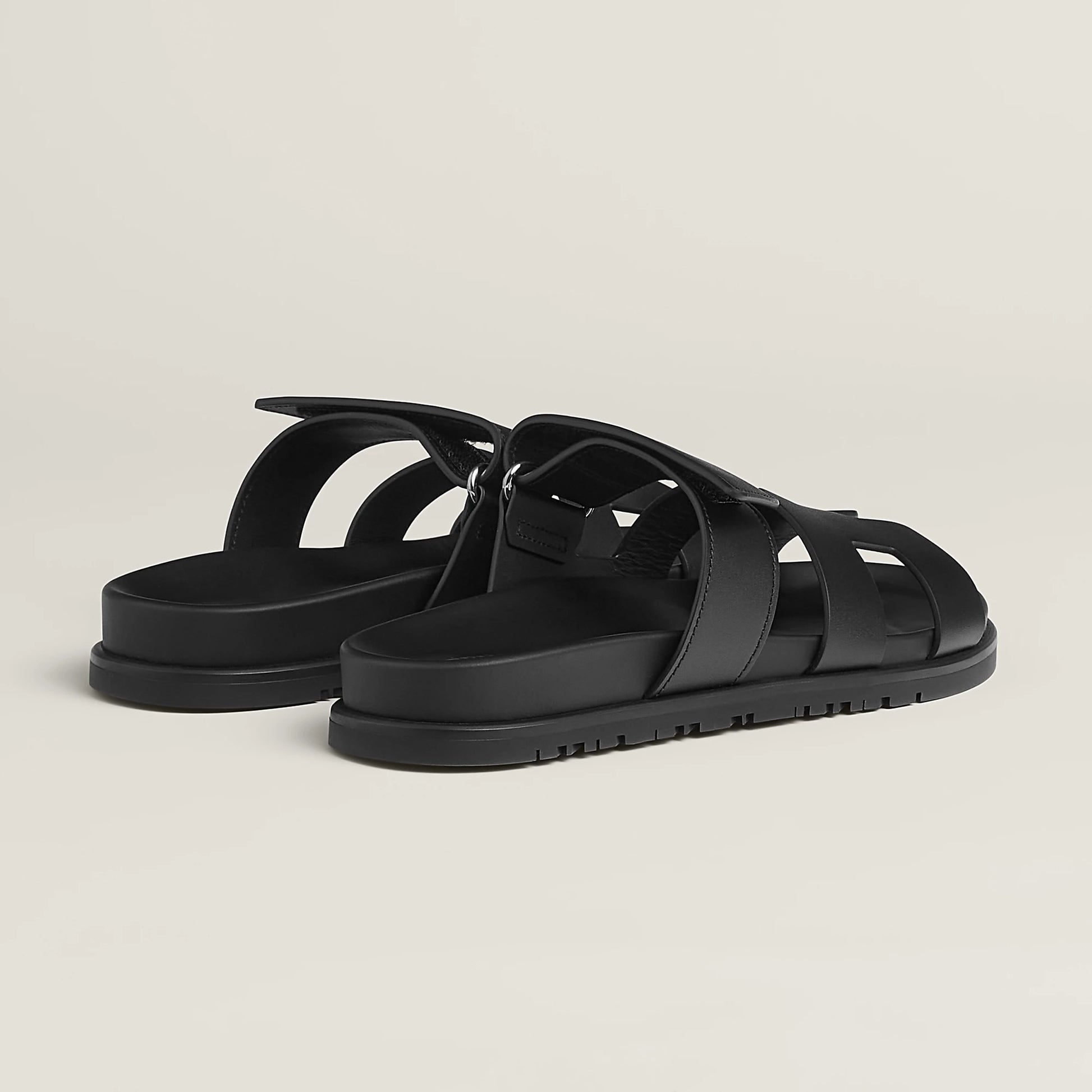 Black suede flat slide sandals with cross straps and buckle ankle strap