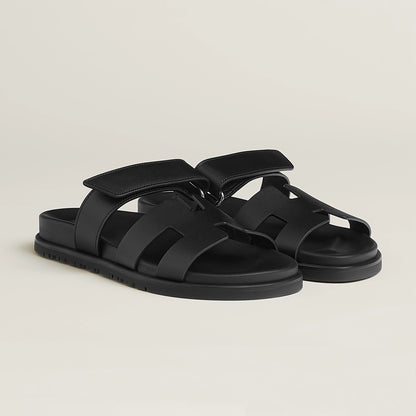 Black suede slide sandals with adjustable buckle strap and cushioned footbed
