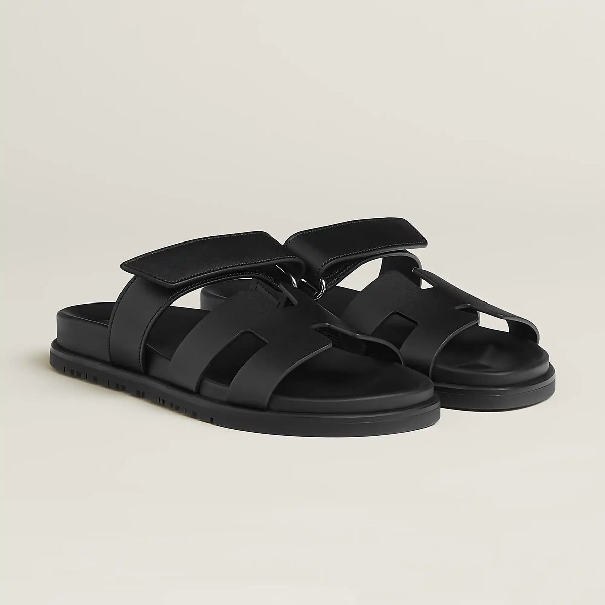 Black suede slide sandals with adjustable buckle strap and cushioned footbed