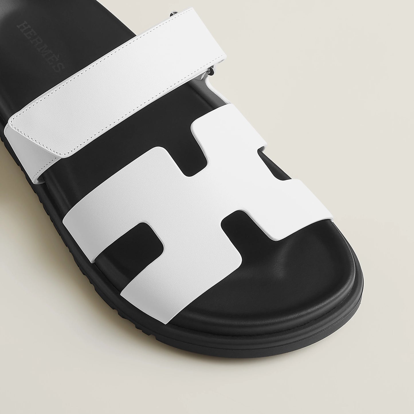 White suede slide sandals close-up, wide strap over molded footbed