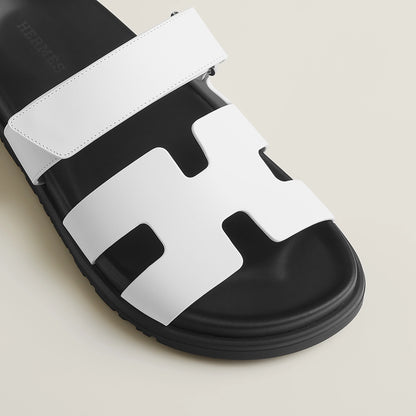White suede slide sandals close-up, wide strap over molded footbed