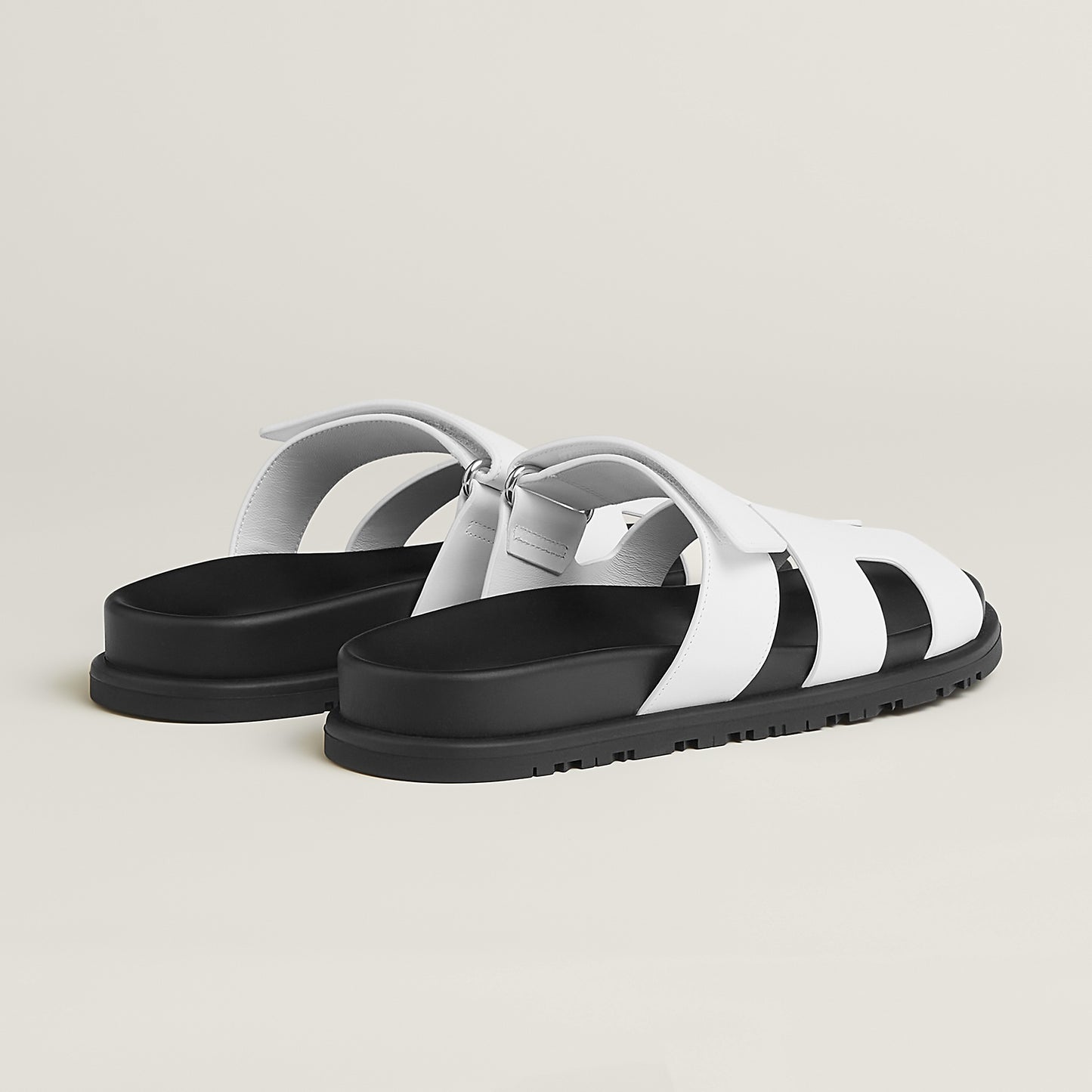 White suede slide sandals with H-style cutout straps and buckle closure