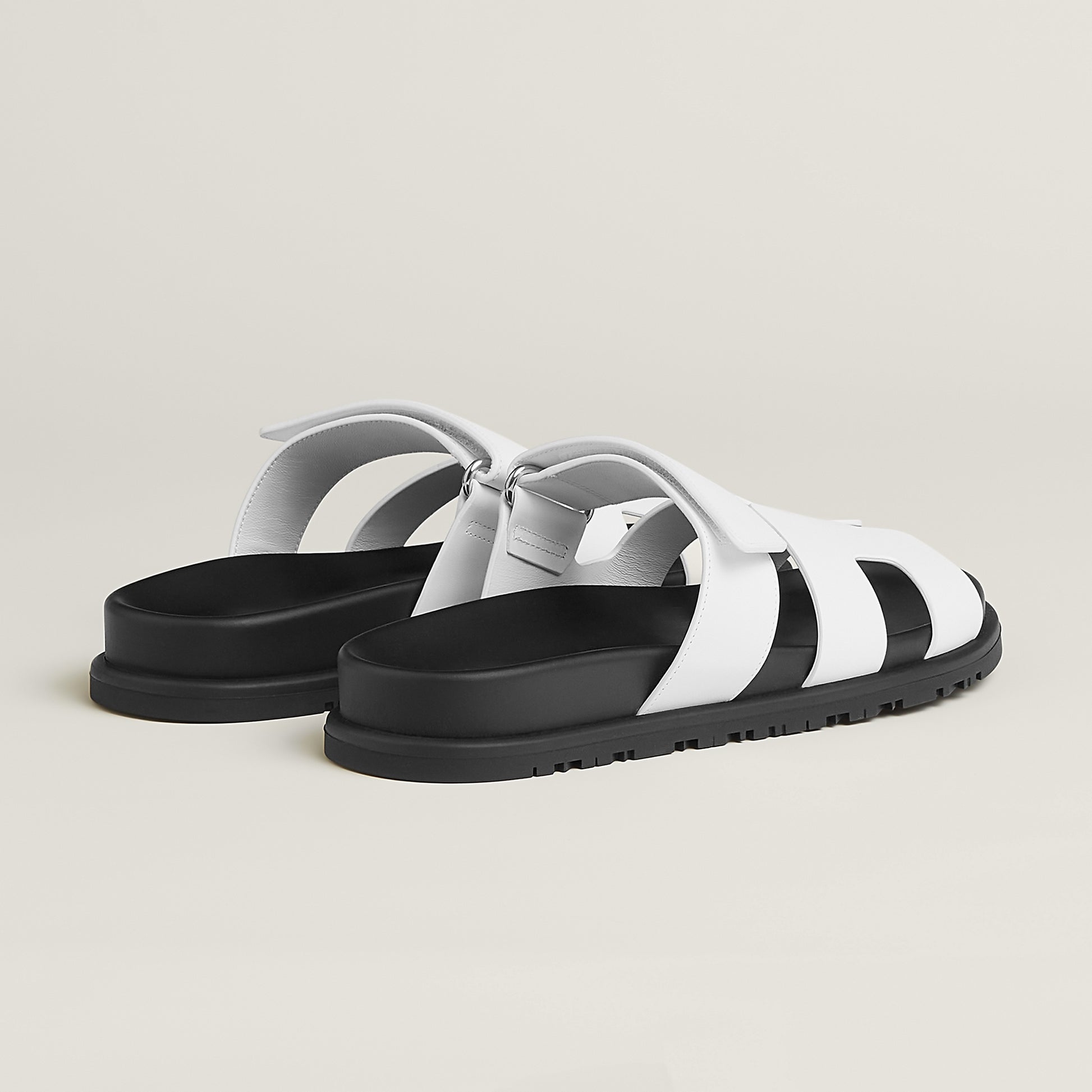 White suede slide sandals with H-style cutout straps and buckle closure