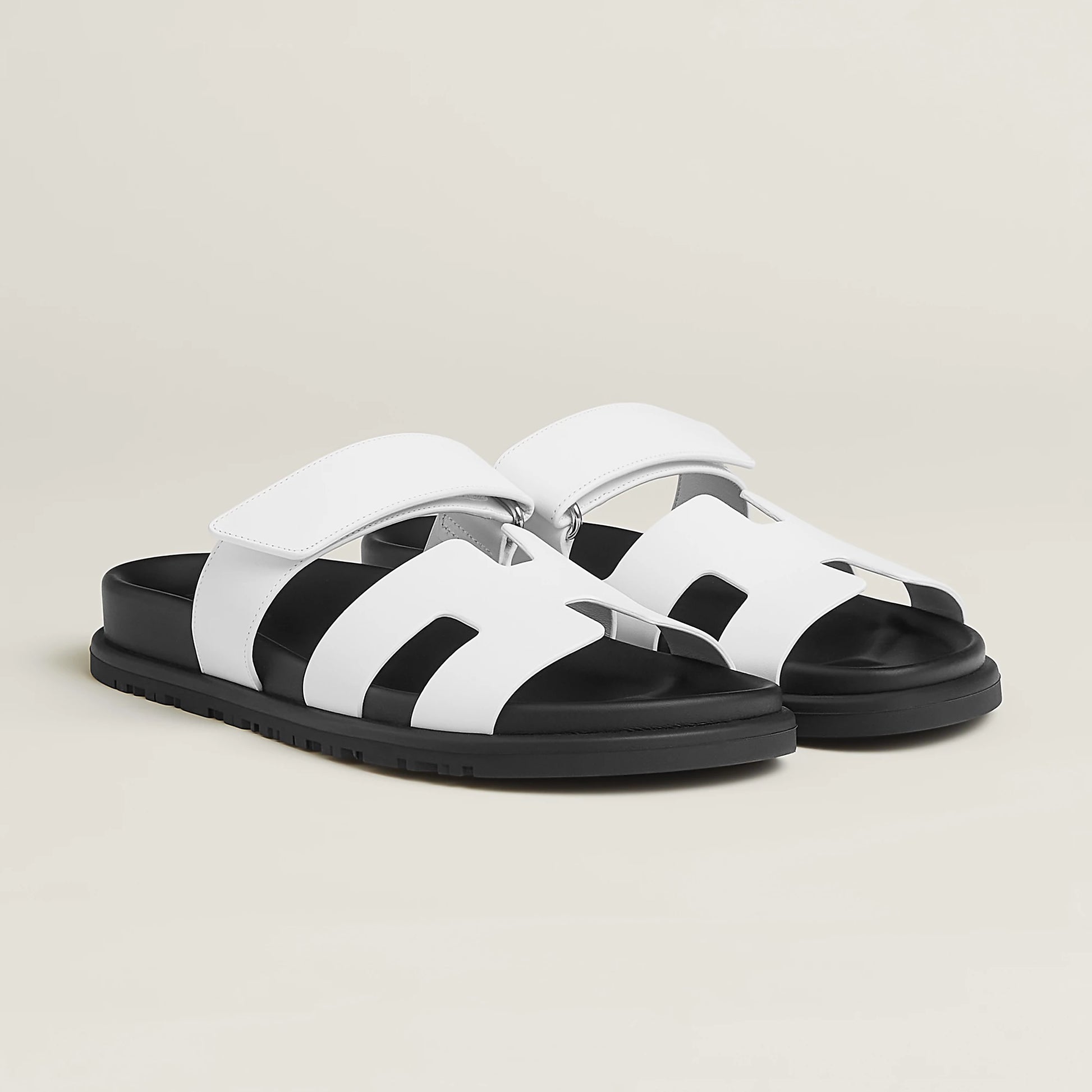 White suede slide sandals with wide straps, cushioned footbed, and chunky sole