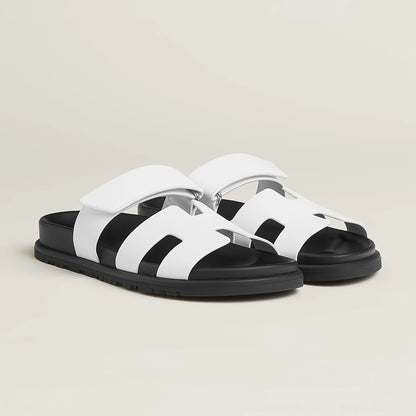 White suede slide sandals with wide straps, cushioned footbed, and chunky sole