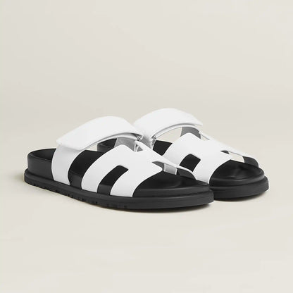 White suede slide sandals with wide straps, cushioned footbed, and chunky sole