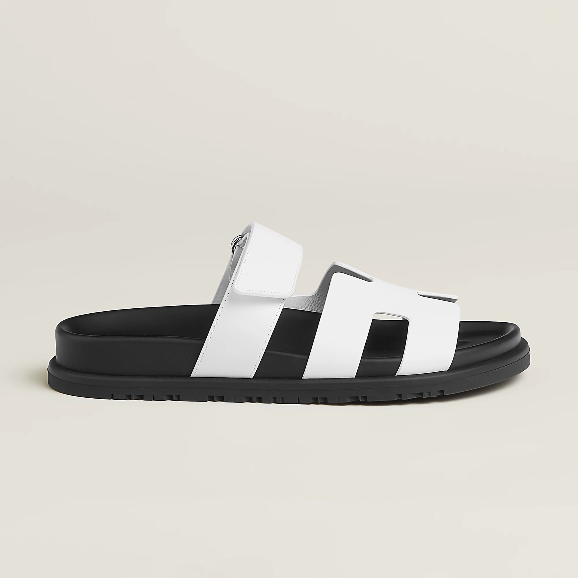 White suede slide sandals with wide H-style straps and buckle ankle strap