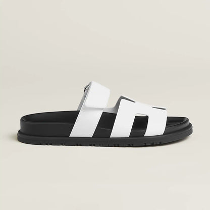 White suede slide sandals with wide H-style straps and buckle ankle strap