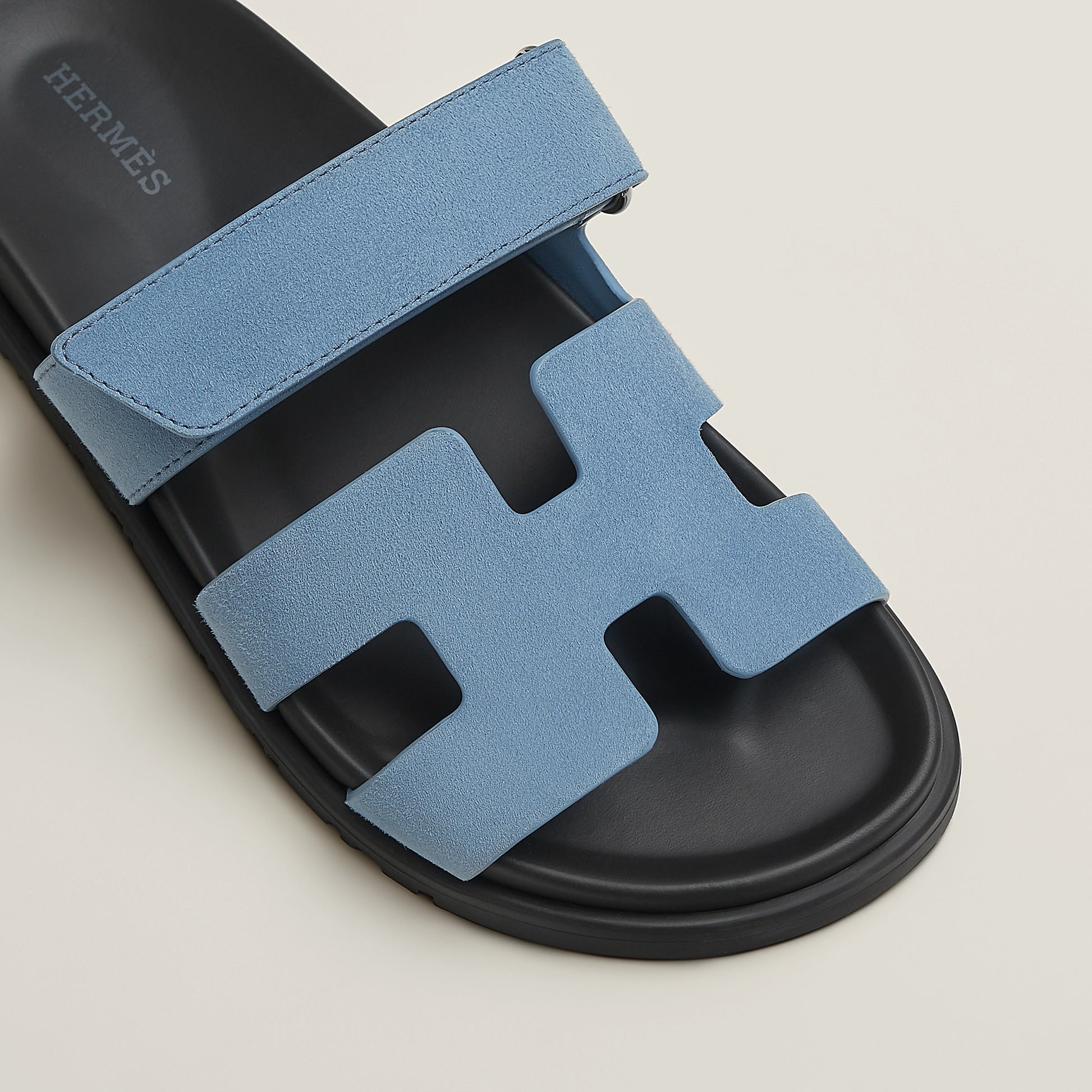 Blue suede slide sandal with H-style cutout straps and black rubber sole