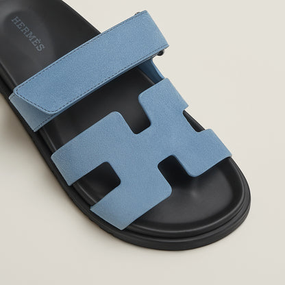 Blue suede slide sandal with H-style cutout straps and black rubber sole