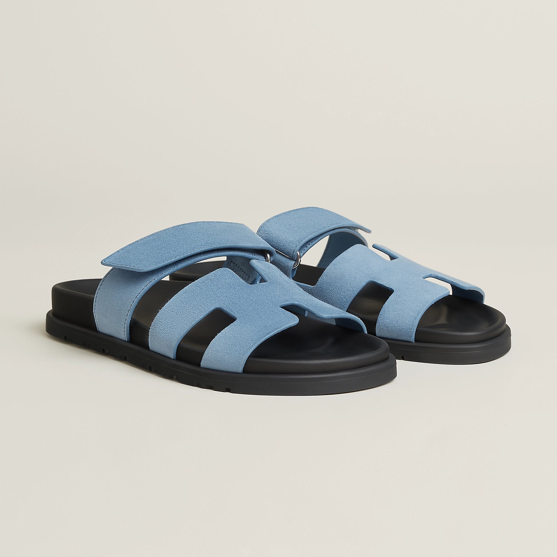 Light blue suede slide sandal with three strap cutouts and black rubber sole