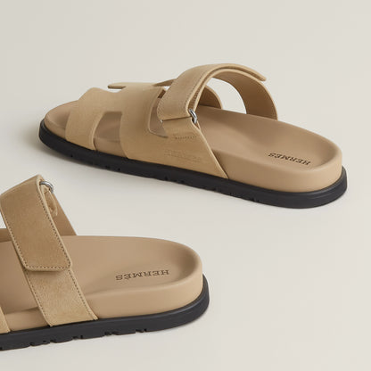 Beige suede slide sandal with wide toe straps and black rubber sole
