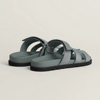 Gray suede slide sandal with cross straps and black rubber sole