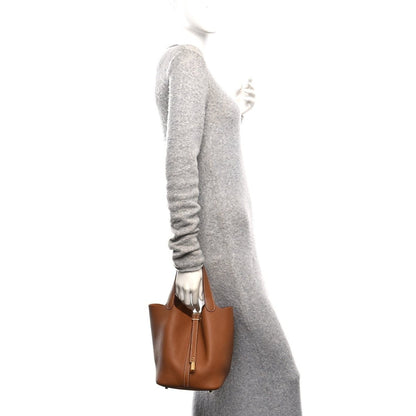 Calfskin leather tote with top handles and vertical lock strap, shown from the side
