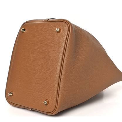 Calfskin leather tote with top handles, corner studs, and gold hardware lock, 3/4 view
