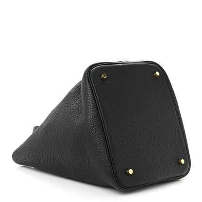 Black pebbled leather tote handbag with gold-tone corner studs and angled shape.