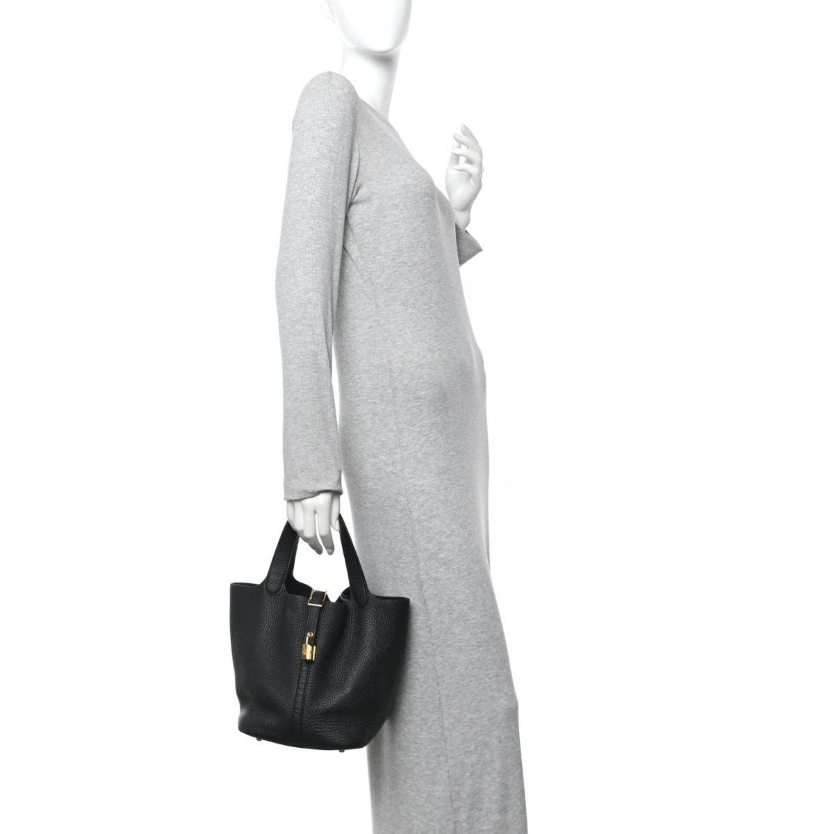 Black lock tote handbag with top handles, side view on a person.