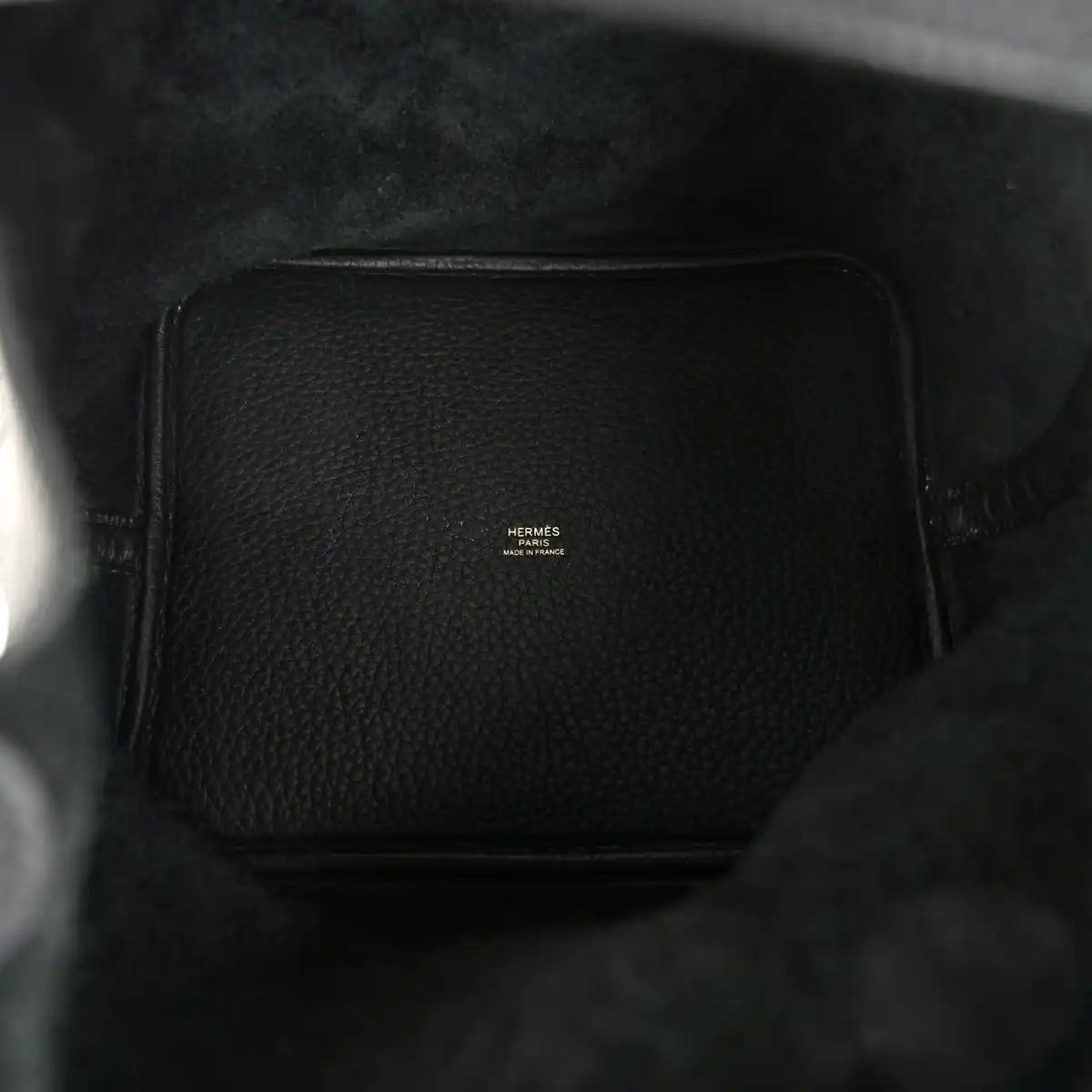 Black leather interior of a tote handbag with a small logo patch.
