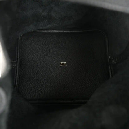 Black leather interior of a tote handbag with a small logo patch.