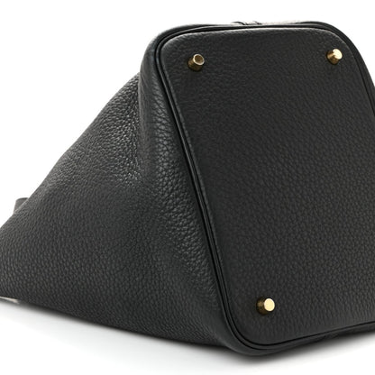 Black pebbled leather tote handbag with corner studs and top zipper edge.