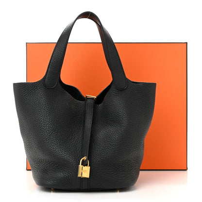Black leather tote handbag with two handles and front turn-lock clasp