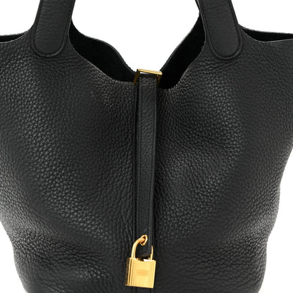 Black tote handbag with gold-tone lock and zipper pull centered on front.