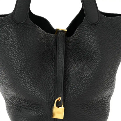Black tote handbag with gold-tone lock and zipper pull centered on front.