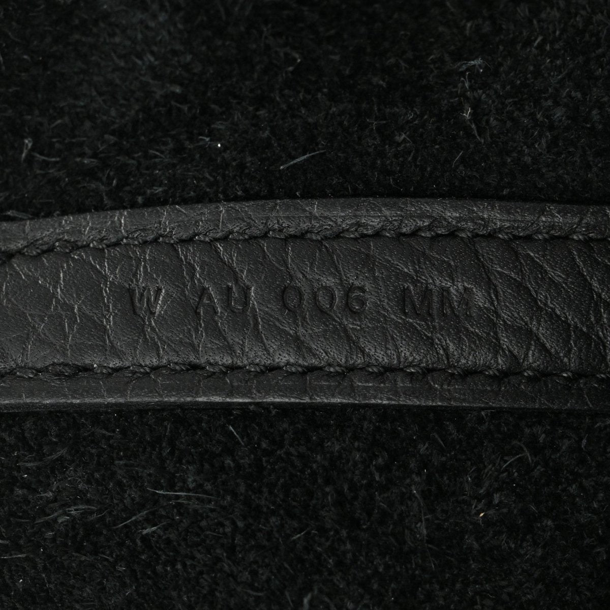 Black leather tote seam with embossed '...406...' marking.