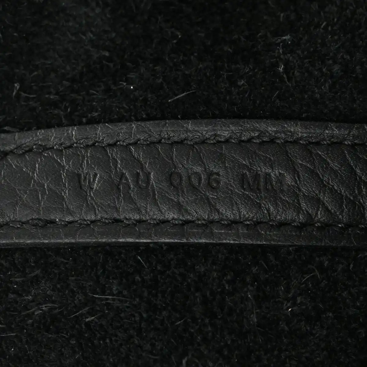 Black leather tote seam with embossed '...406...' marking.