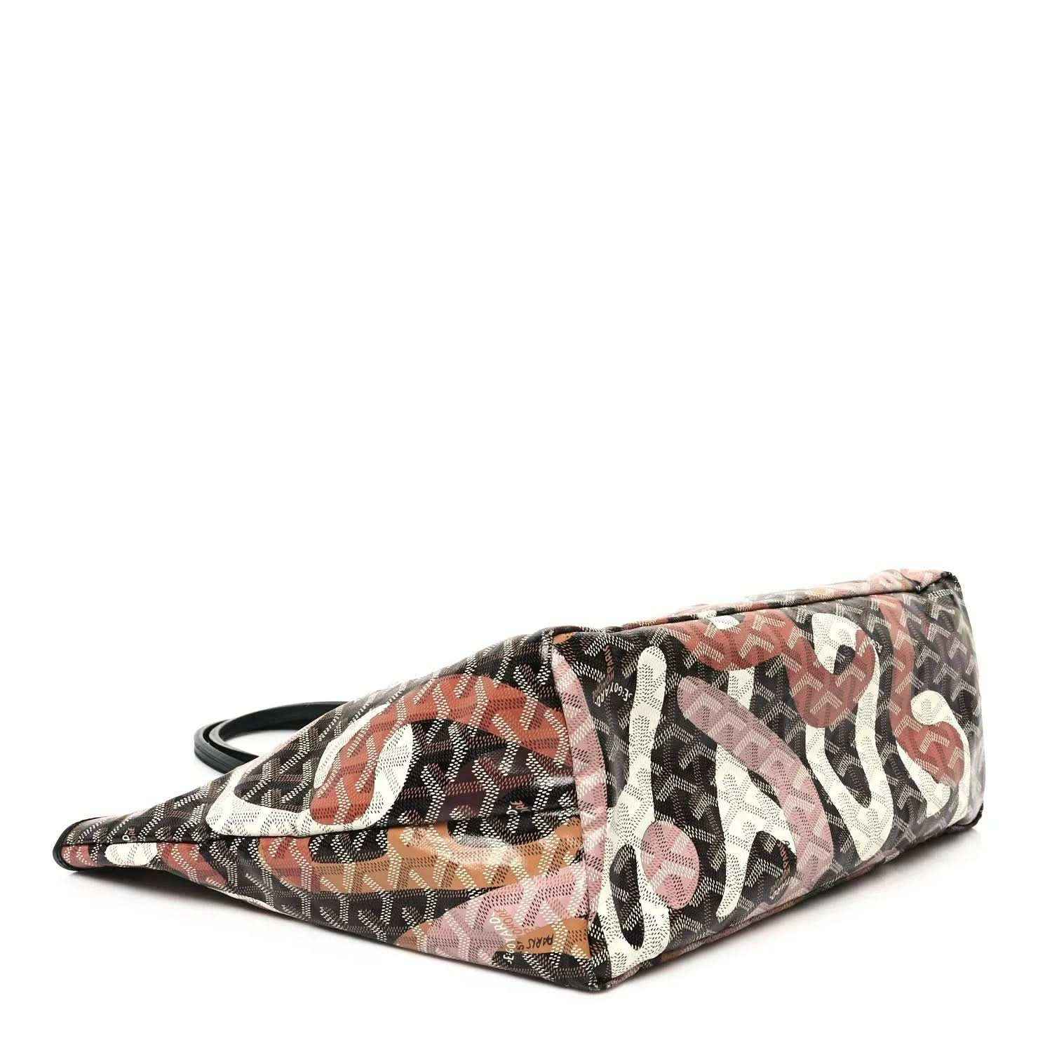 PM tote bag laid on its side, dark monogram fabric with pink and orange letter artwork
