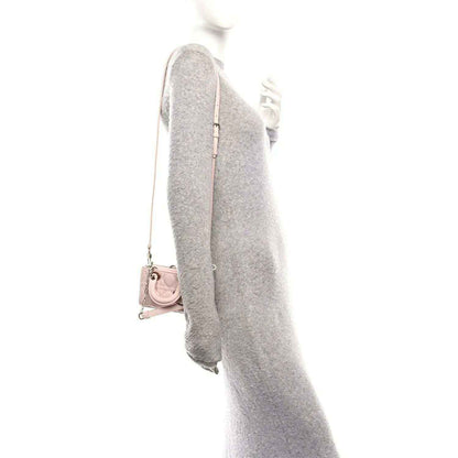 Pink leather mini handbag with chain strap, shown from side with back panel