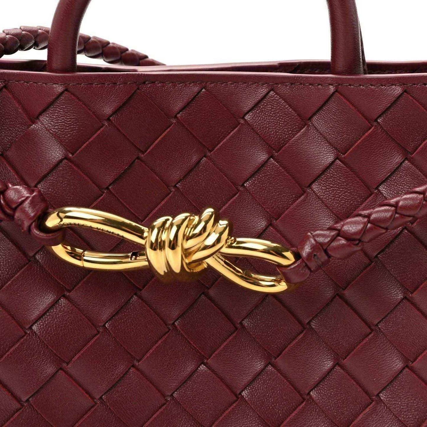 Burgundy intrecciato nappa leather bag with gold clasp and braided woven details.