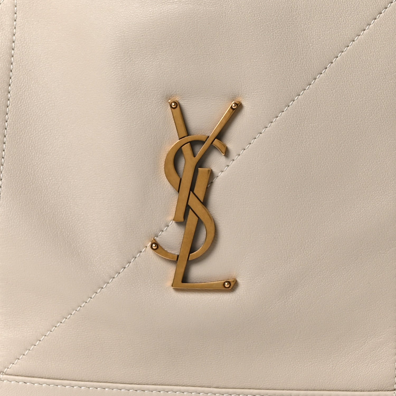 Gold YSL logo on cream lambskin tote bag panel with visible stitching
