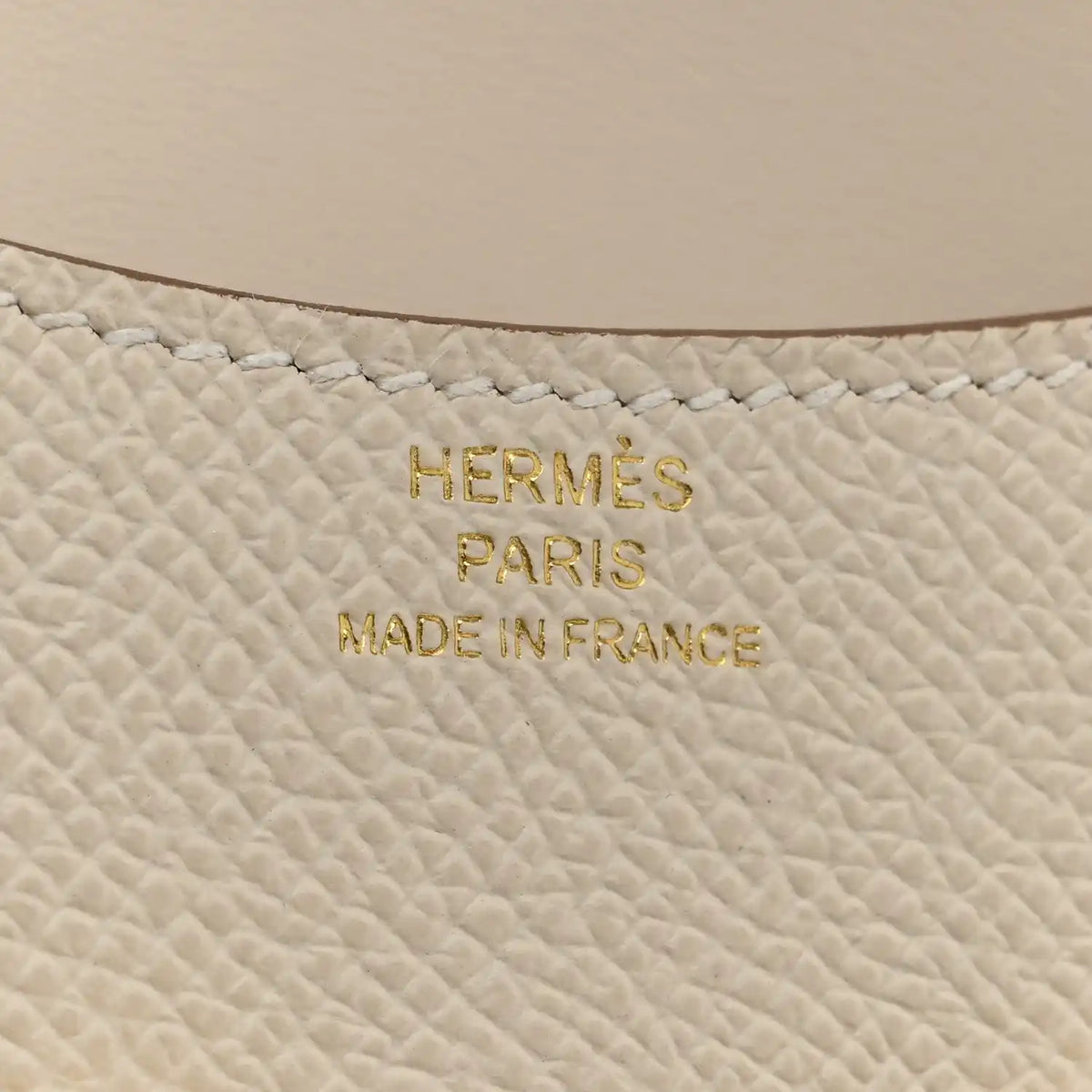 Hermès PARIS MADE IN FRANCE embossed on light cream textured leather