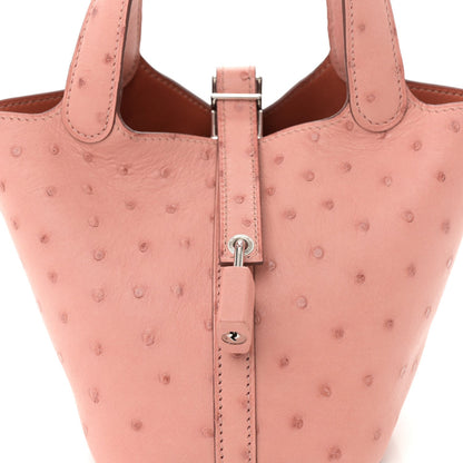 Detail of light pink ostrich leather mini bucket bag: silver lock hardware and keyhole