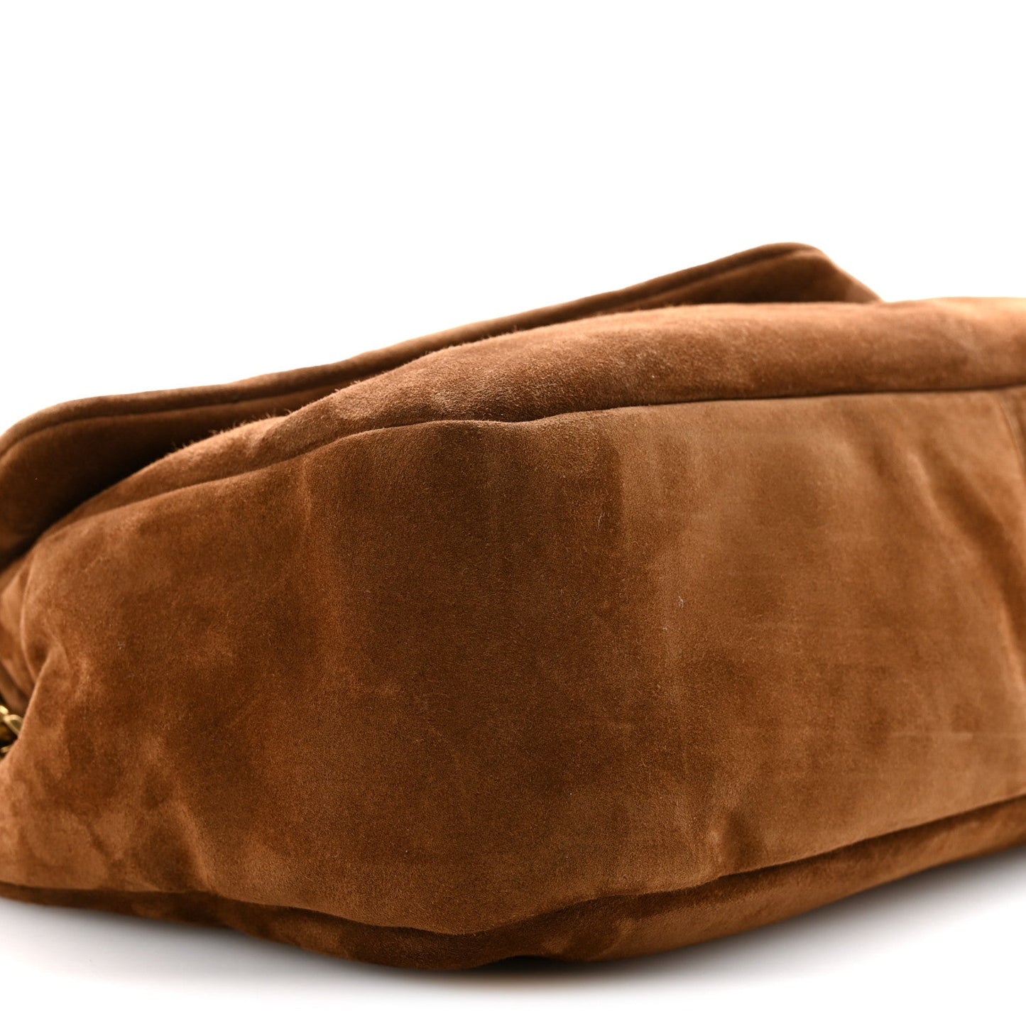 Saint Laurent suede shoulder bag close-up in caramel cognac with curved bottom seam.