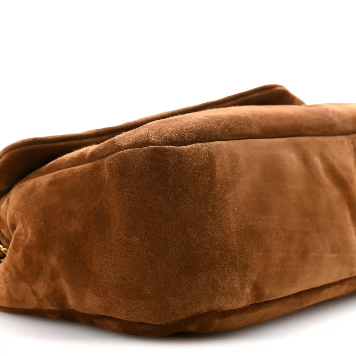 Saint Laurent suede shoulder bag close-up in caramel cognac with curved bottom seam.