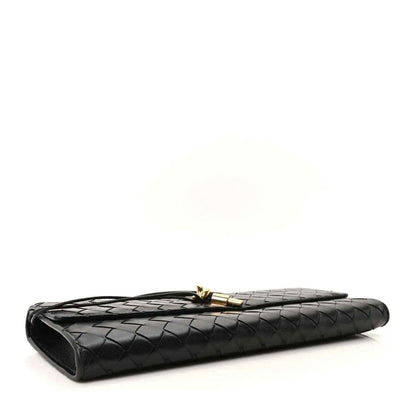 Black woven leather clutch with gold clasp and curved side edge
