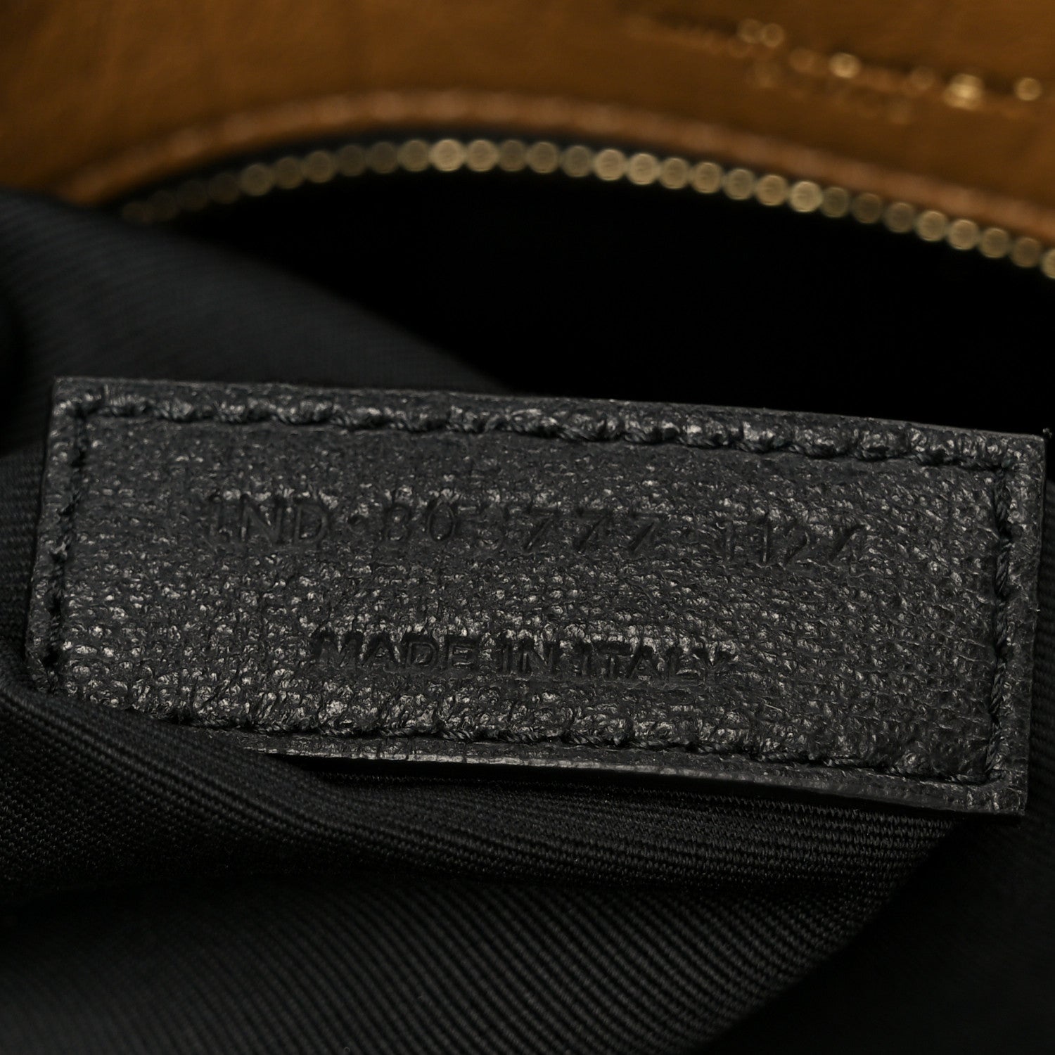 Satchel interior lining with stitched brand patch and zipper trim.