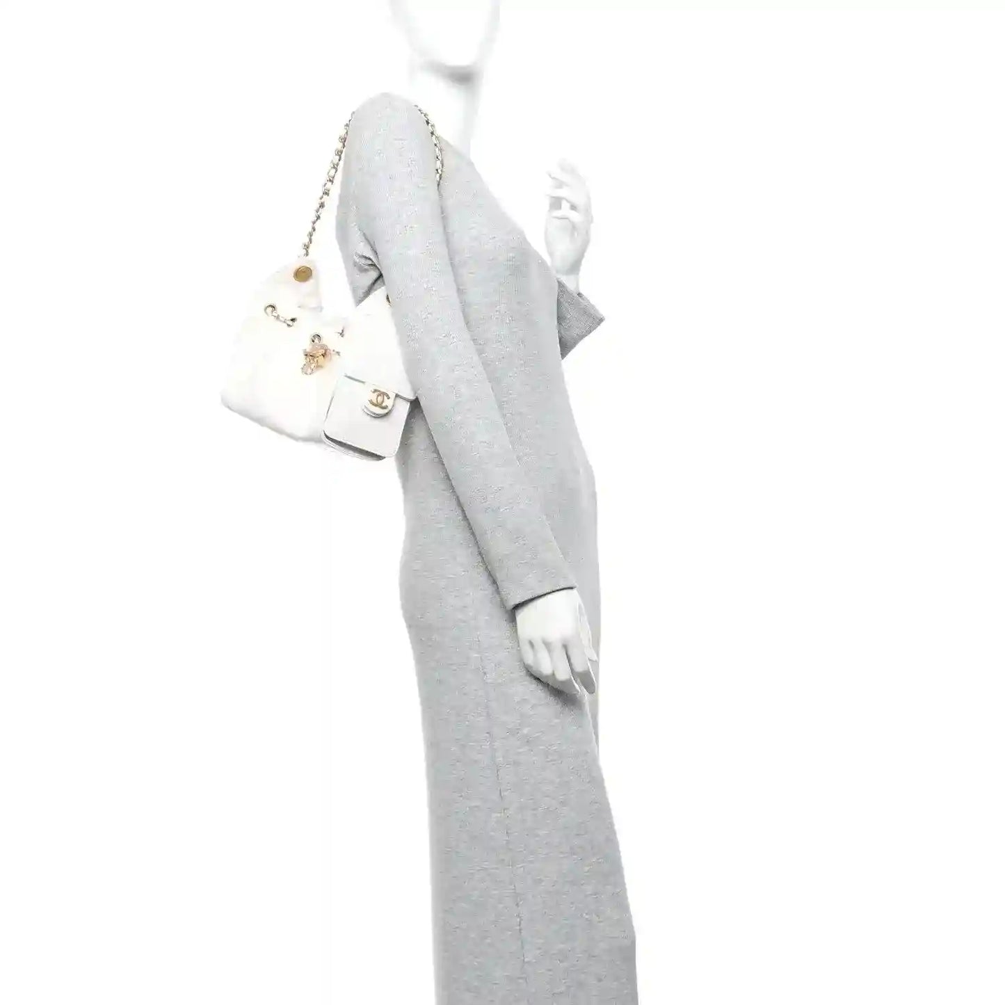 White quilted mini handbag worn on shoulder with gold-tone chain strap and small front pocket